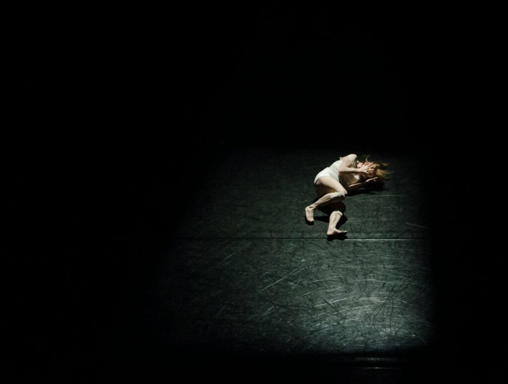 a person standing on a tennis court in the dark