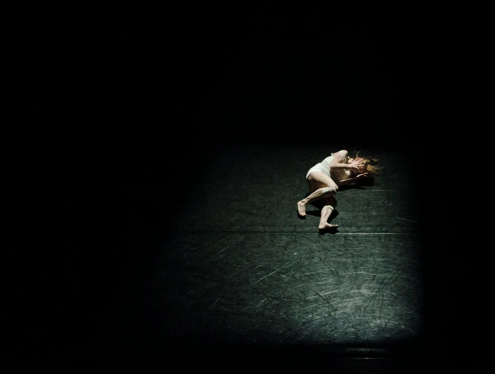 a person standing on a tennis court in the dark